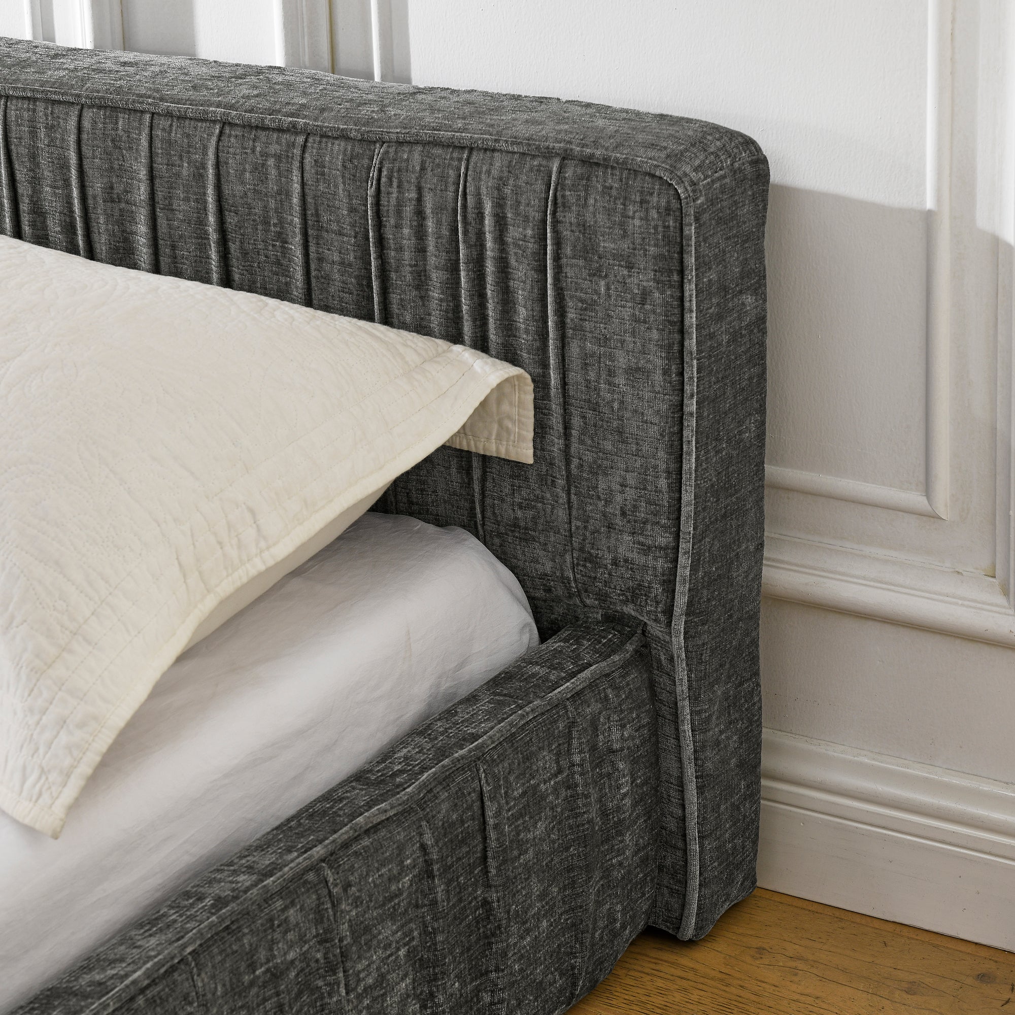 The large grey padded bed frame is designed with Chenille fabric